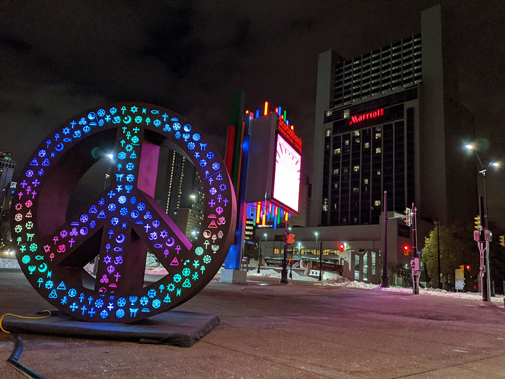 Symbolic Peace - a 10ft tall peace sign light sculpture with light.